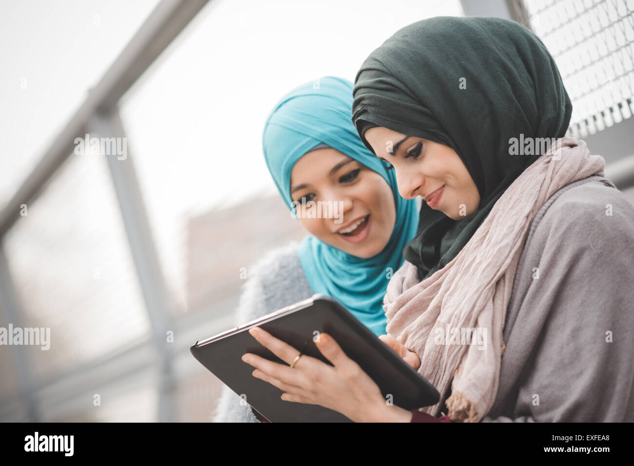 Zwei junge Frauen tragen Hijab mit digital-Tablette auf Steg Stockfoto