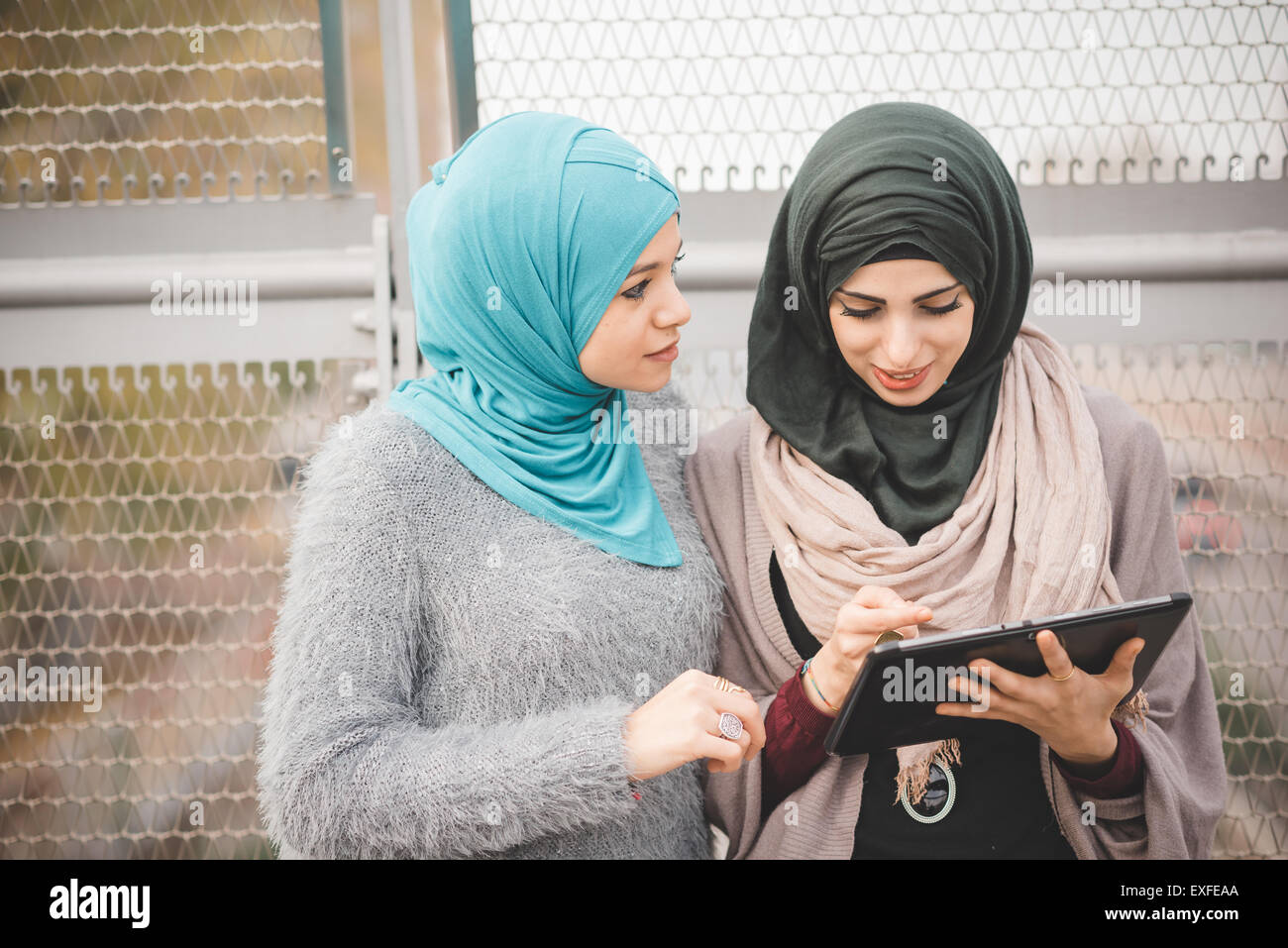 Zwei junge Frauen tragen Hijab mit Touchscreen auf digital-Tablette auf Steg Stockfoto