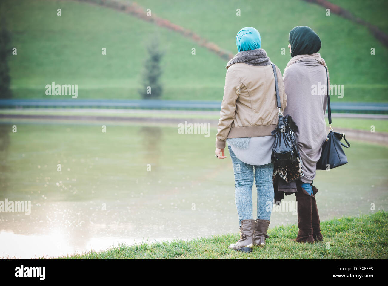 Rückansicht der beiden jungen Frauen mit Blick vom Seeufer Stockfoto