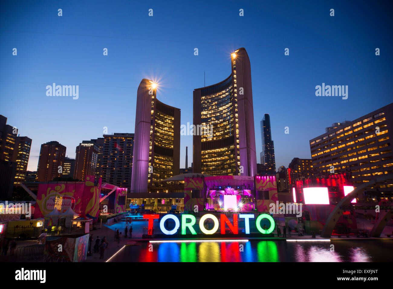 TORONTO, Kanada-Juli 9,2015: Das neuen Toronto Zeichen in Nathan Phillips Square feiert die PanAm-Spiele des neuen Rathauses am Rücken. Bühne montiert statt eine konstante Partei namens Panamania Stockfoto