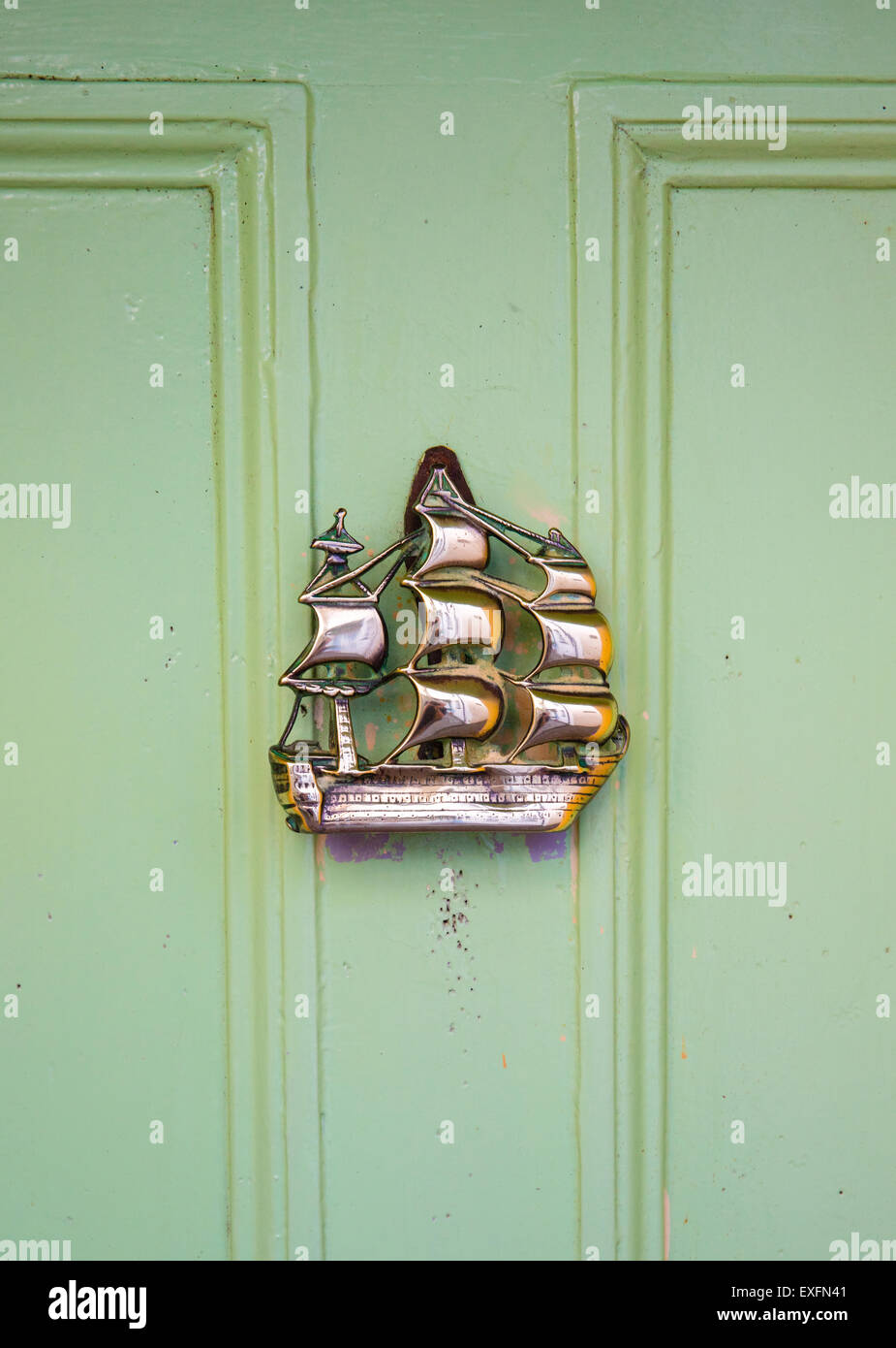 Messing Türklopfer in Form einer Galeone an einer grünen Tür im Dorf Clovelly an der Küste von North Devon Stockfoto