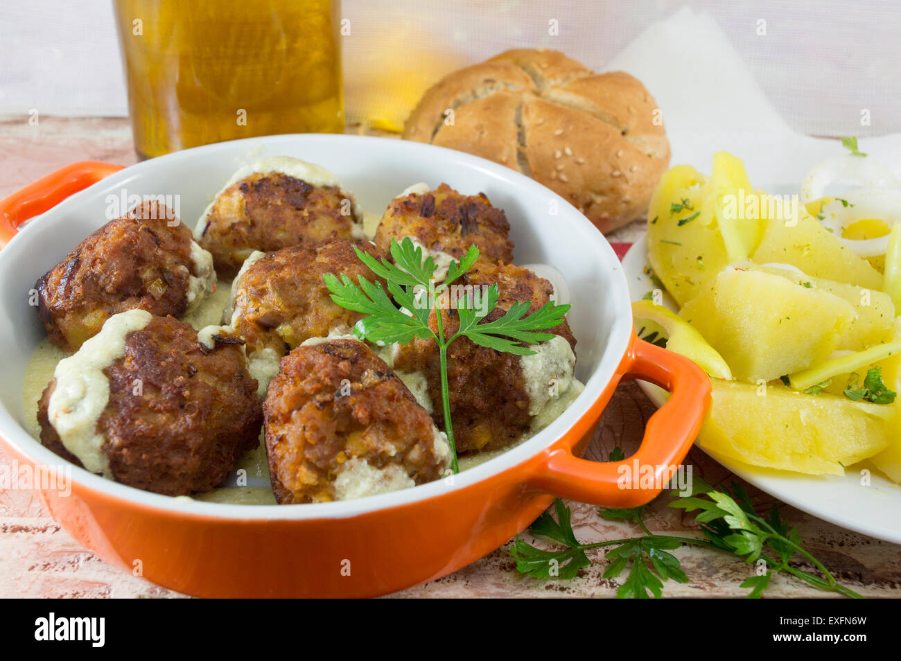 Hausgemachte Frikadellen mit Mais-Brot, gekochte Kartoffeln und Olivenöl in eine orange Schüssel serviert Stockfoto