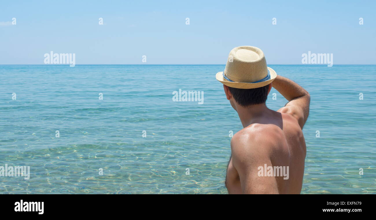Junger Mann, Blick auf den Horizont Stroh Hut Stockfoto