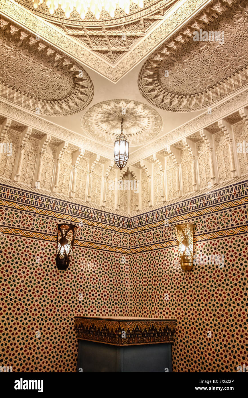 Exquisite Details eines traditionellen Riad Salons in Fez, mit Zellige-Fliesen-Motiven und kunstvoll geformter Gipsdecke Stockfoto