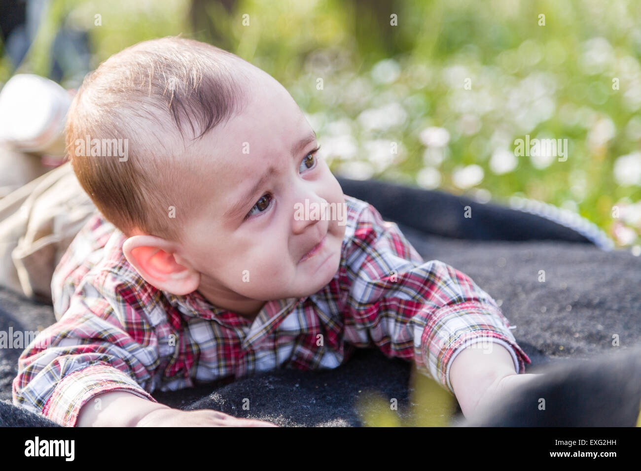 Süße 6 Monate altes Baby mit hellbraunen Haaren in rot karierten Hemd und  Beige Hose leider verzweifelten Blick aber Fanny Gesicht zeigt  Stockfotografie - Alamy