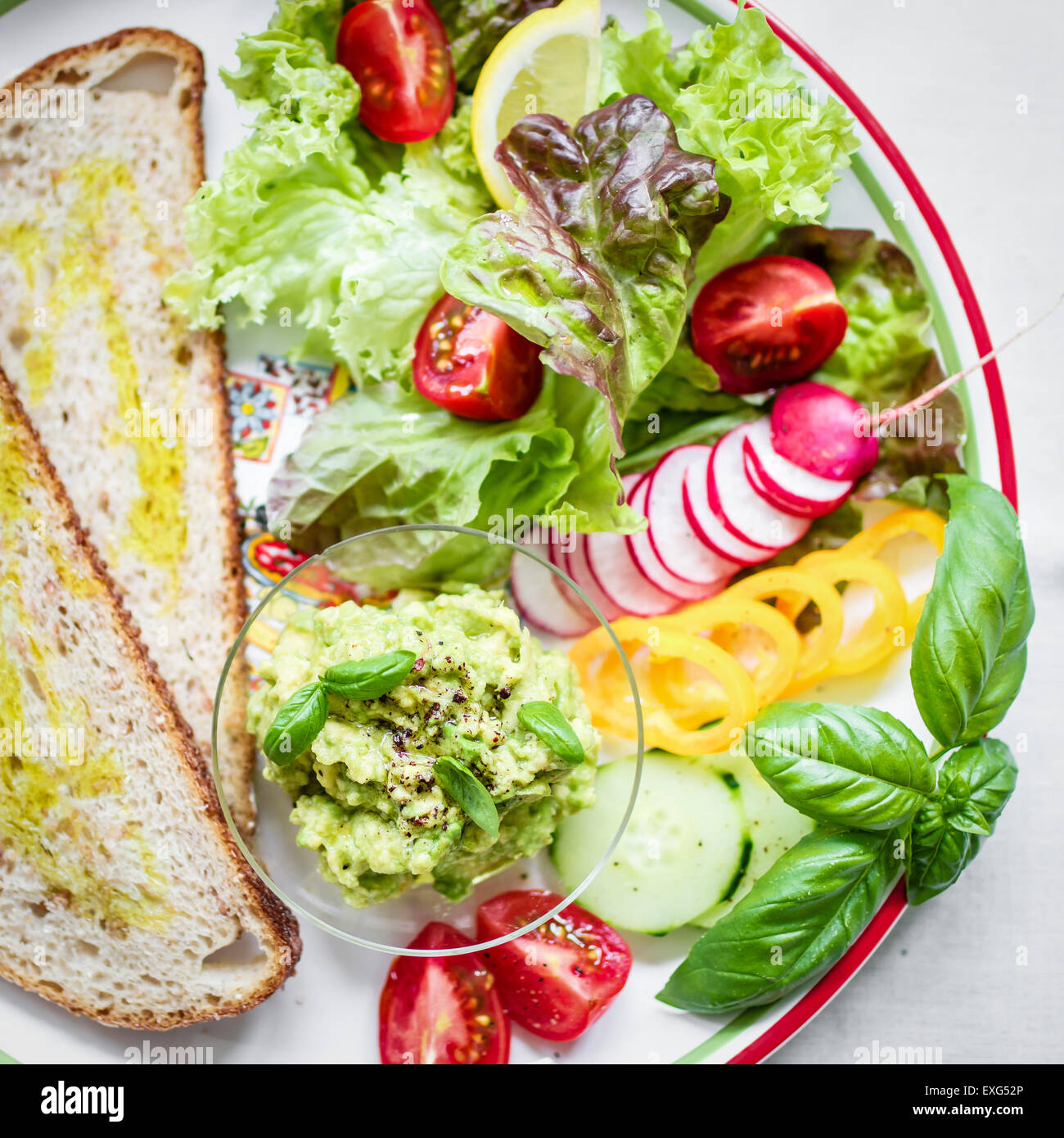 Teller mit Brot und frisches Gemüse für vegane Frühstück/Mittagessen. Ansicht von oben. Stockfoto
