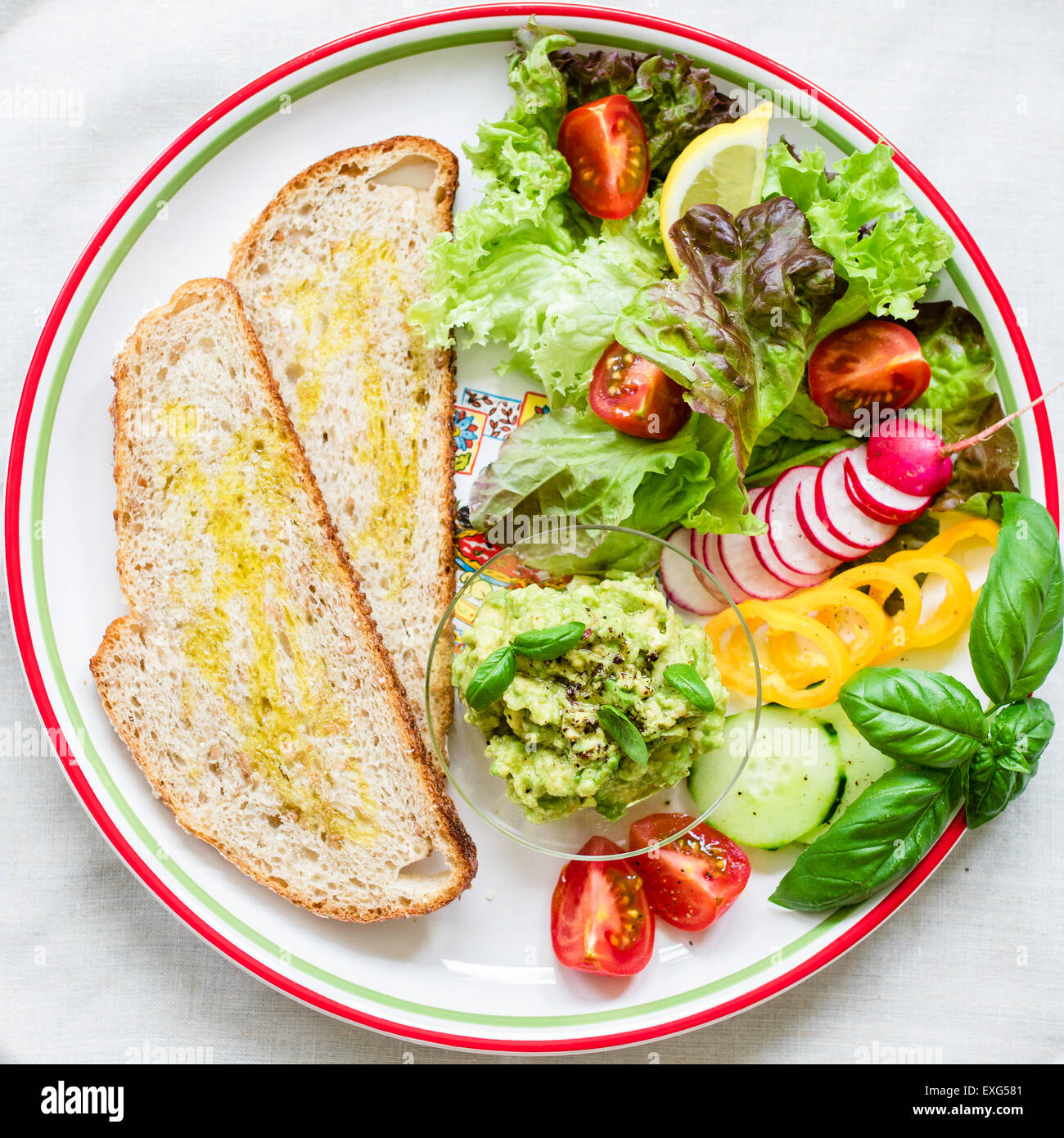 Teller mit Brot und frisches Gemüse für vegane Frühstück/Mittagessen. Ansicht von oben. Stockfoto
