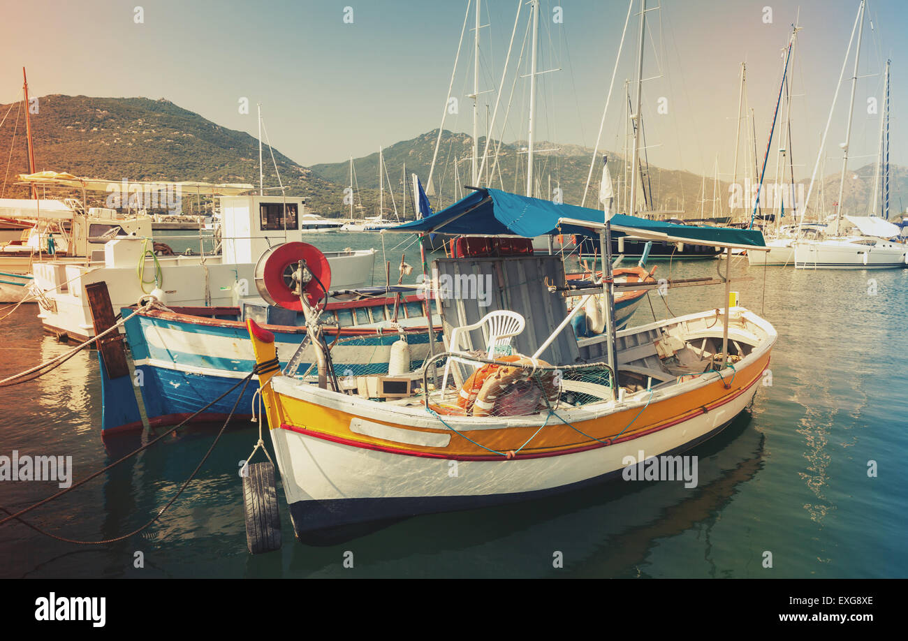Kleine bunte hölzerne Fischerboote vertäut in der Stadt Propriano, Korsika, Frankreich. Vintage getönten Foto mit alten Stil Filterwirkung Stockfoto