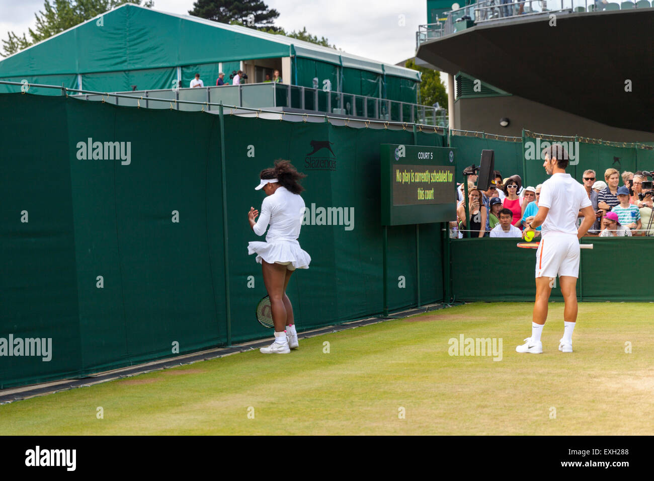 Serena Williams dauert einen Moment für sich, beobachtet von Trainer Patrick Mouratoglou, während Aufwärmen, Wimbledon Championships 2015 Stockfoto