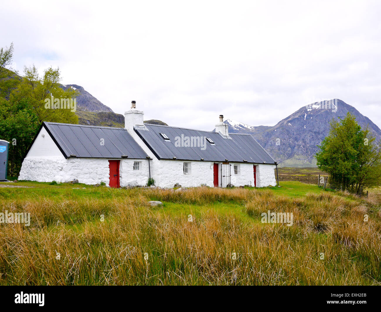 Schwarz-Ferienhaus mit Buchaille Etive Mor im Hintergrund, Rannoch Moor, Glencoe, Scotland, UK. Stockfoto