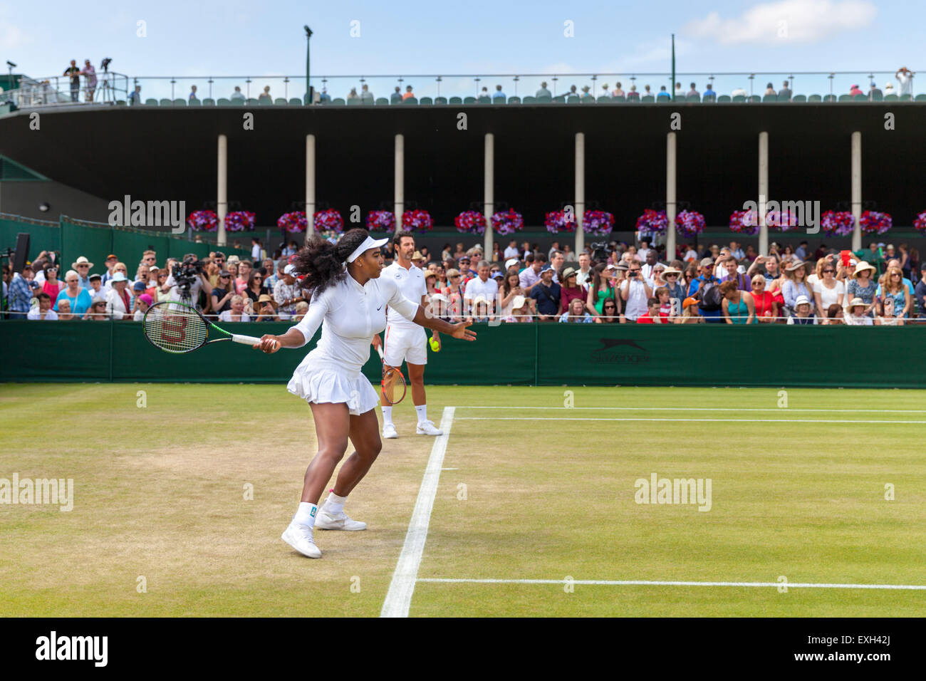 Serena Williams erwärmt sich für das Spiel auf Platz Nr. 5, geholfen durch Trainer Patrick Mouratoglou, während der Wimbledon Championships 2015 Stockfoto