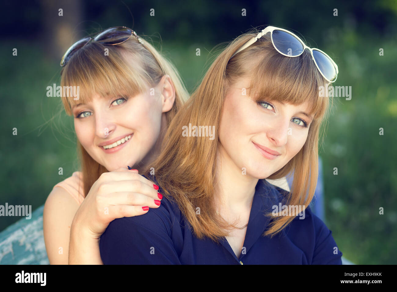 Porträt der Zwillinge Schwestern im Park. Zwei schöne junge Mädchen auf der Suche gerade. Warme Farbe getönt Bild Stockfoto