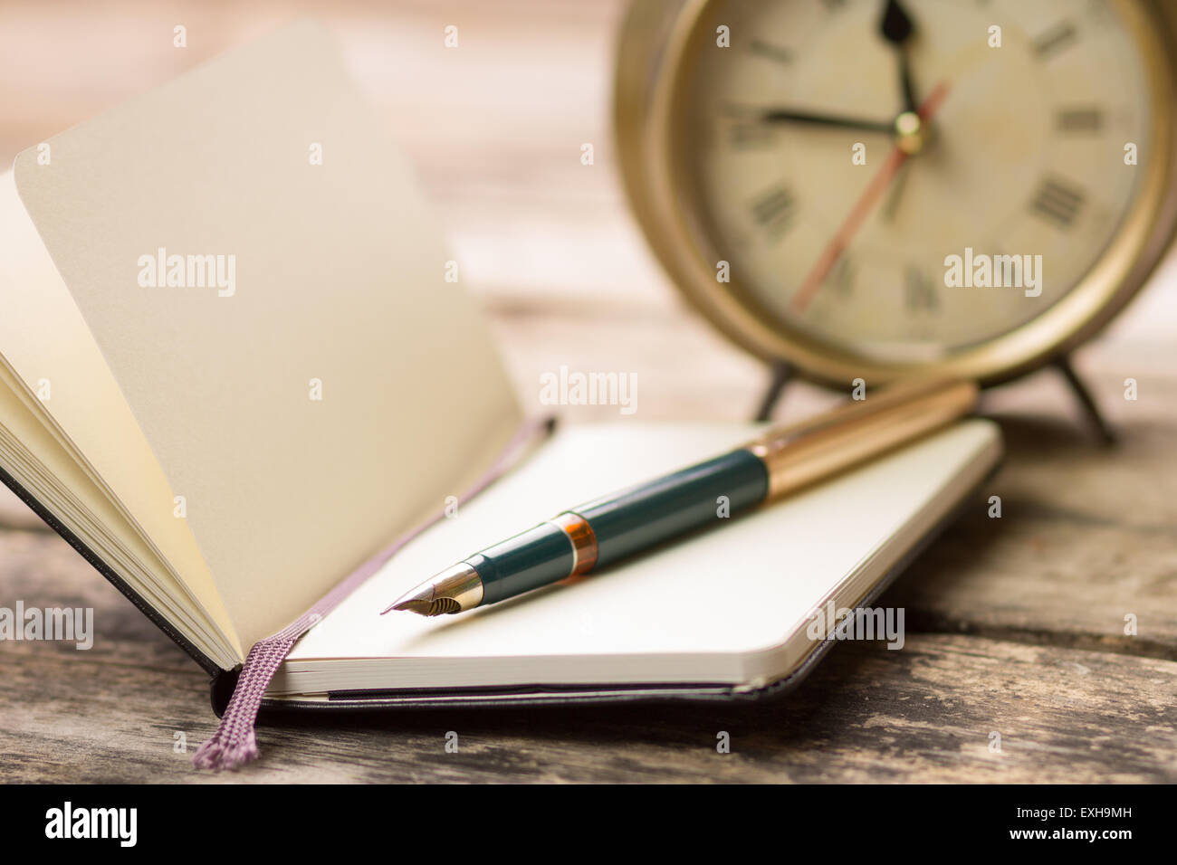 Offene kleine Notebook mit Füllfederhalter und altmodische Wecker hinter.  Hintergrundbild mit selektiven Fokus schreiben Stockfotografie - Alamy