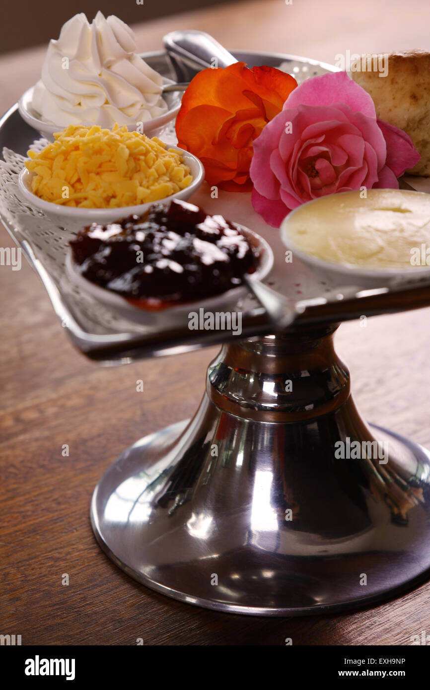 Köstliche Butter Gebäck auf einem Tablett Silber in Herzform mit Rosen Käse Sahne serviert und Marmelade auf einem Holztisch bewahrt. Stockfoto