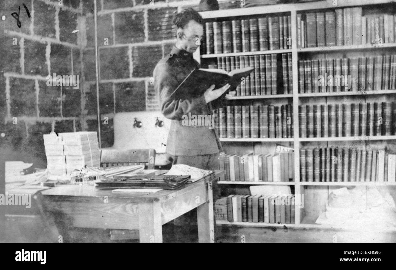 Dieses Bild zeigt einen Mann, der in einem Büro ein Buch liest. Das Thema ist in das Lesematerial eingetaucht und symbolisiert ruhige Konzentration und intellektuelles Engagement in einer professionellen Umgebung. Stockfoto