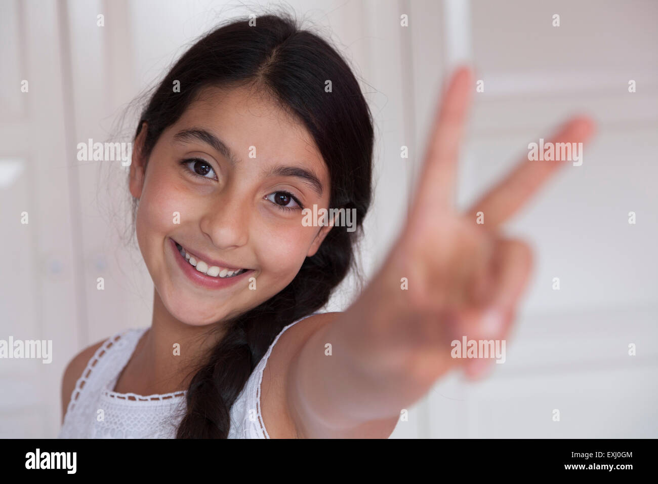 Glücklich Teenager-Mädchen mit V-Zeichen Geste Stockfoto