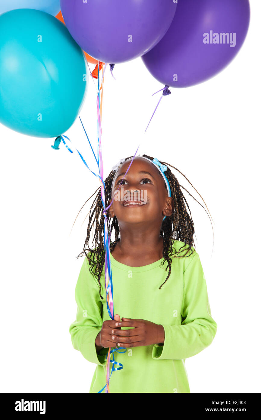 Entzückenden kleinen afrikanischen Kind mit Zöpfen trägt ein leuchtendes grünes Hemd. Das Mädchen hält eine Reihe von hellen farbigen Helium bal Stockfoto