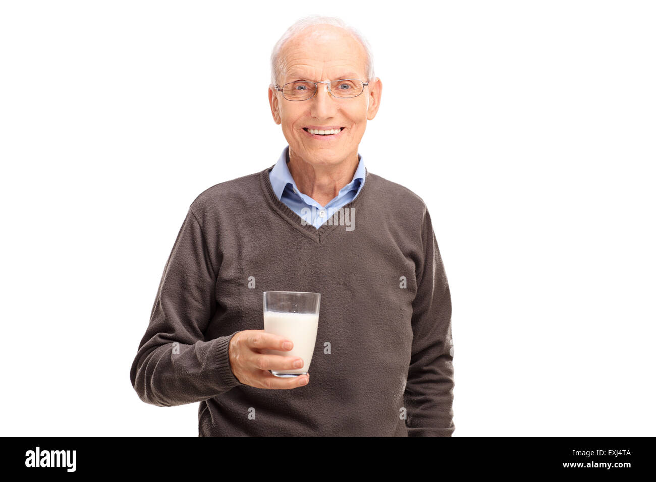Heitere senior Gentleman hält ein Glas Milch und schaut in die Kamera, die isoliert auf weißem Hintergrund Stockfoto