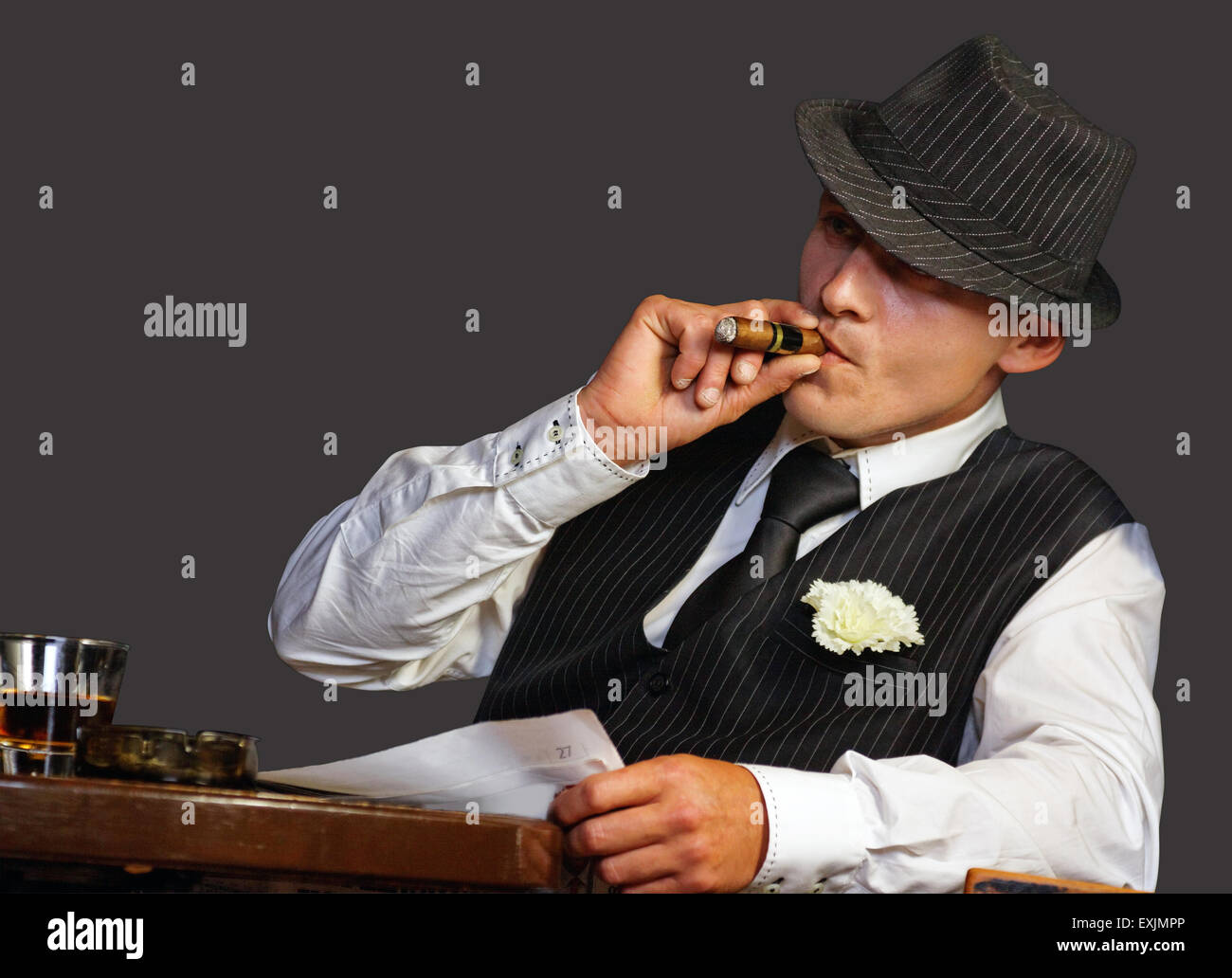 junge Gangster mit Hut Rauchen Zigarre, Studio gedreht Stockfoto