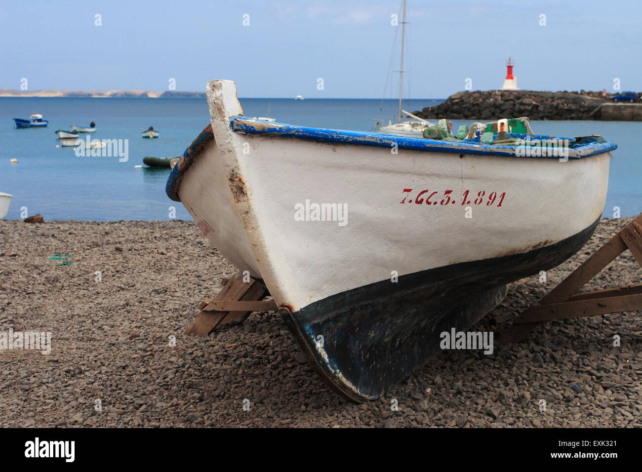 Mediterranen weißen Holz Fischerboot laufen auf einem steinigen Strand in Kanarische Inseln Spanien Stockfoto