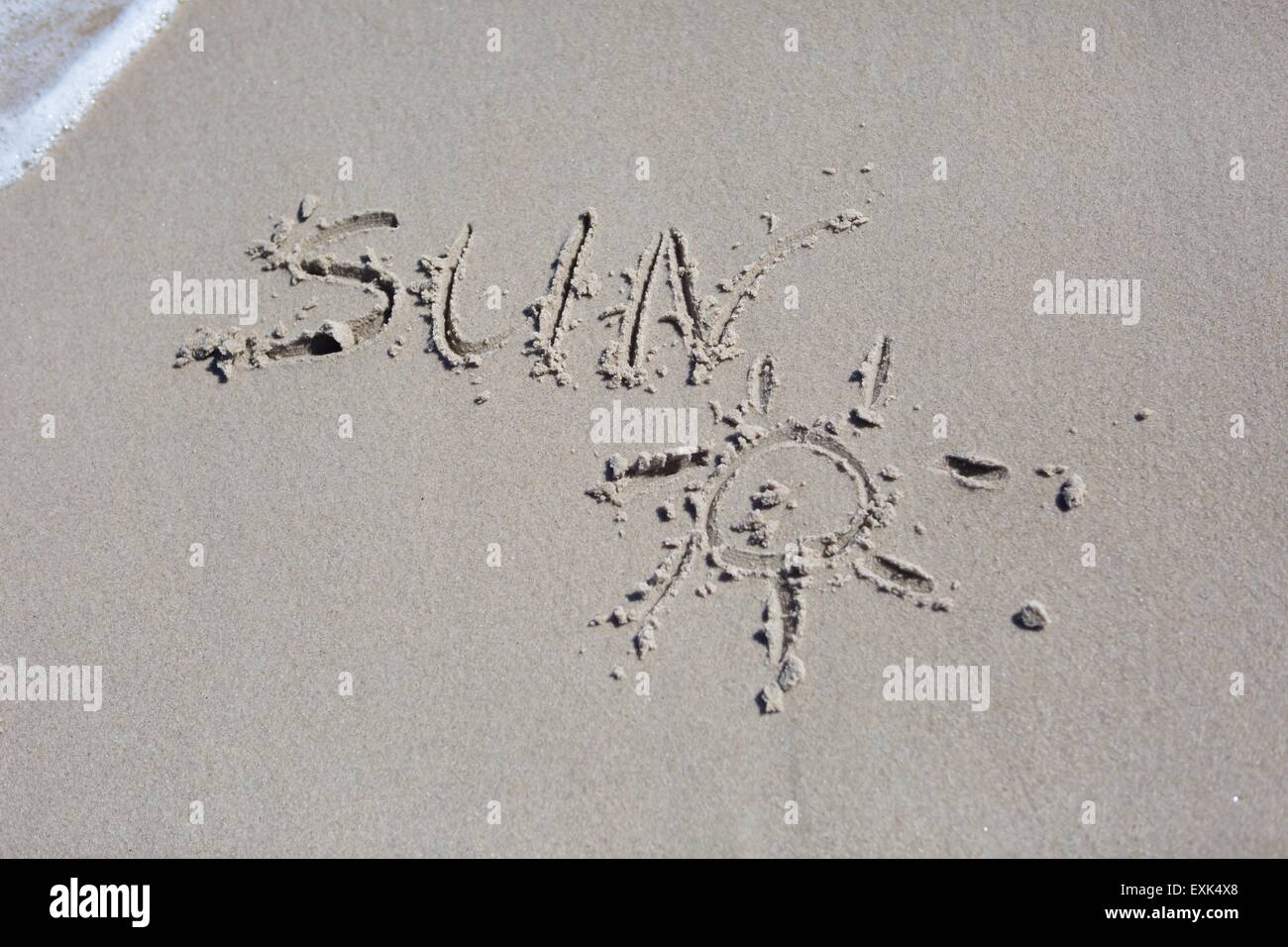 Inschrift auf Strandsand. Meeresküste hautnah mit Inschrift. Sonne Stockfoto