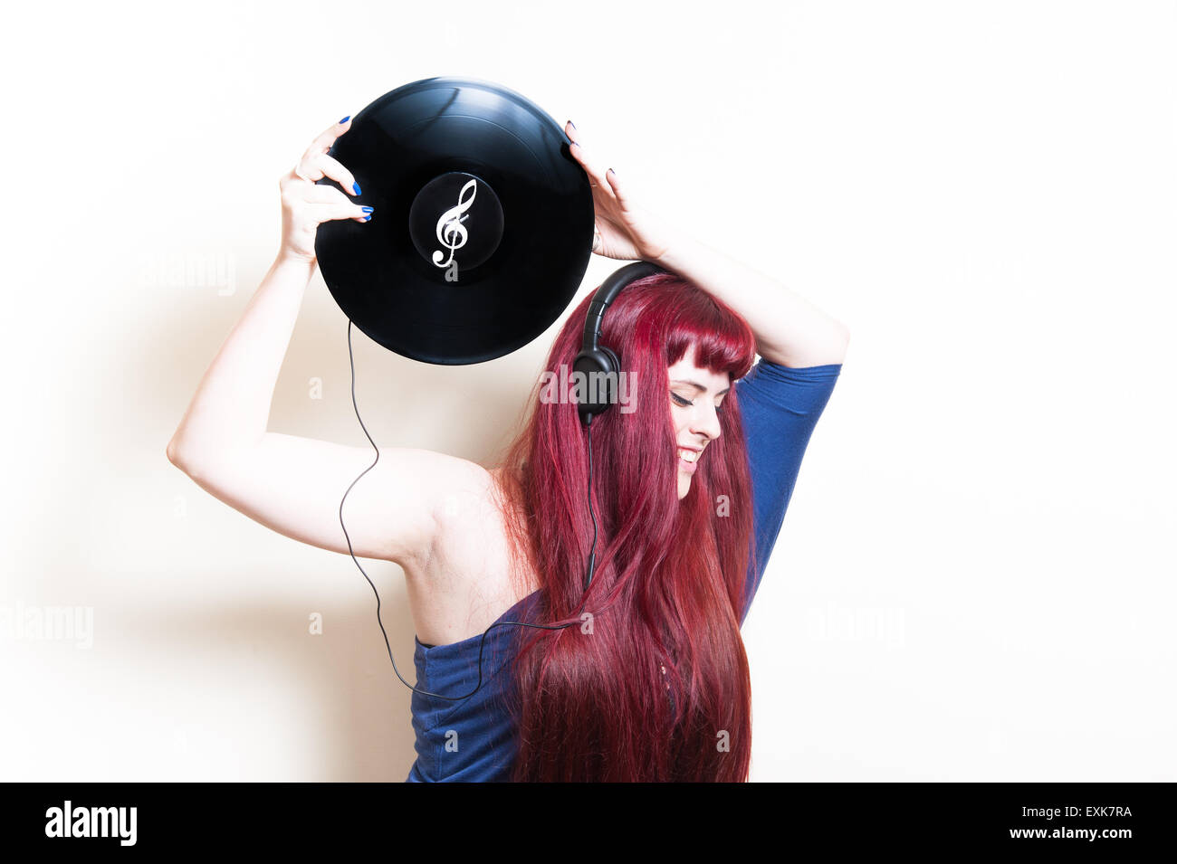 Junge hübsche Frau mit Kopfhörern und Vinyl-Scheibe isoliert auf weißem Hintergrund Stockfoto