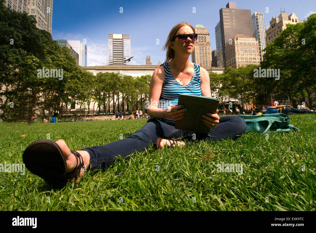 Junge schwangere Frau Recherche auf ihr Tablet im Bryant Park, New York City Stockfoto