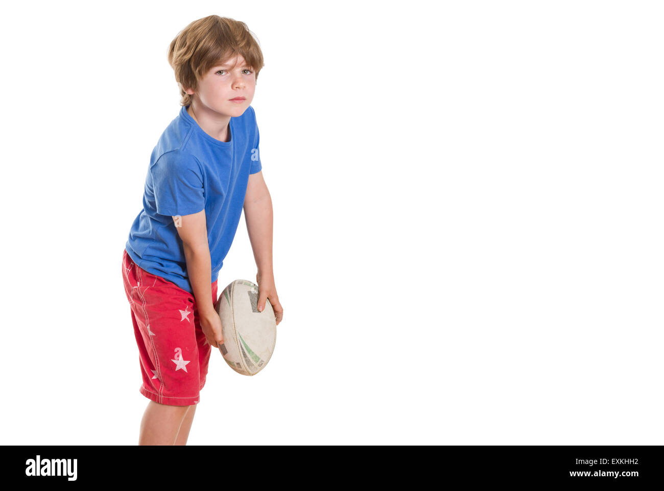 Junge posiert mit Rugby-Liga-Ball zu werfen, mit vielen textfreiraum vorgibt. Stockfoto