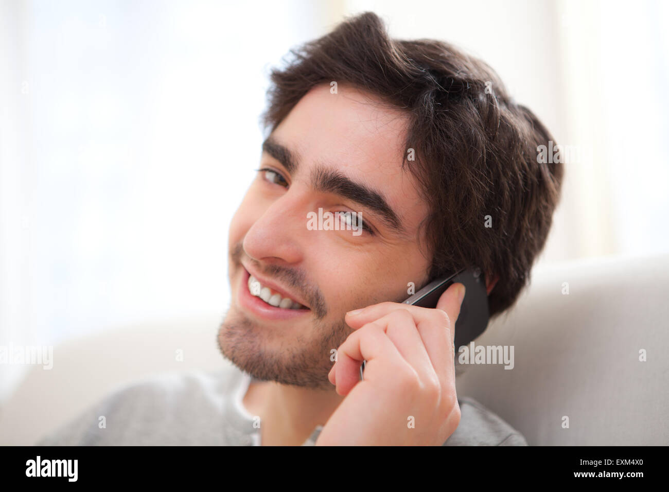 Ansicht eines jungen Mannes mit einem Aufruf in ein sofa Stockfoto