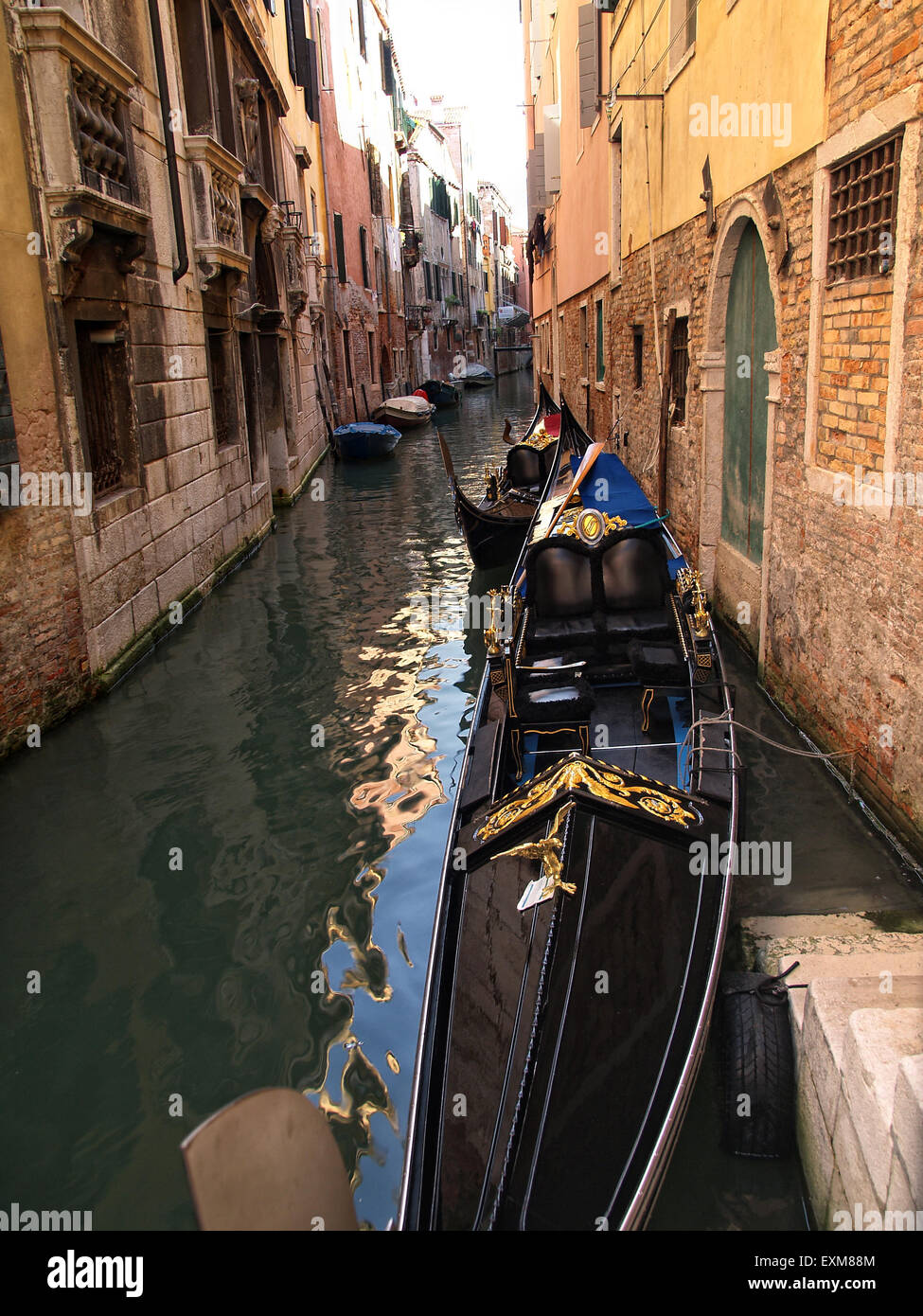 Blick auf eine leere Gondel vertäut in einem engen Kanal in Venedig mit schönen Häusern an den Seiten. Venedig. Italien. Stockfoto