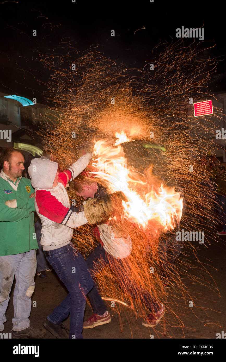 Läufer mit geduscht Funken aus einem brennenden Fass durchgeführt durch die Straße anlässlich Bonfire Night, 5 November, bei den Festspielen Tar Barrel schon St Mary, Devon, England Stockfoto