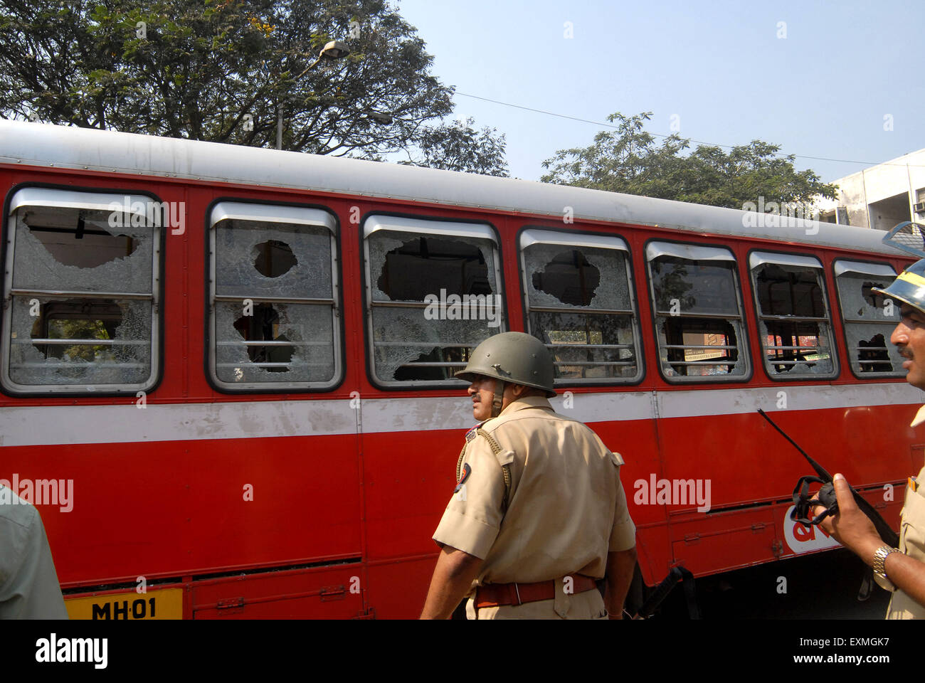 Polizisten bewachen beste Bus mit zerbrochenen Glas nach der Dalit Gemeinschaft Resort zu gewaltsamen Protesten Mumbai Stockfoto