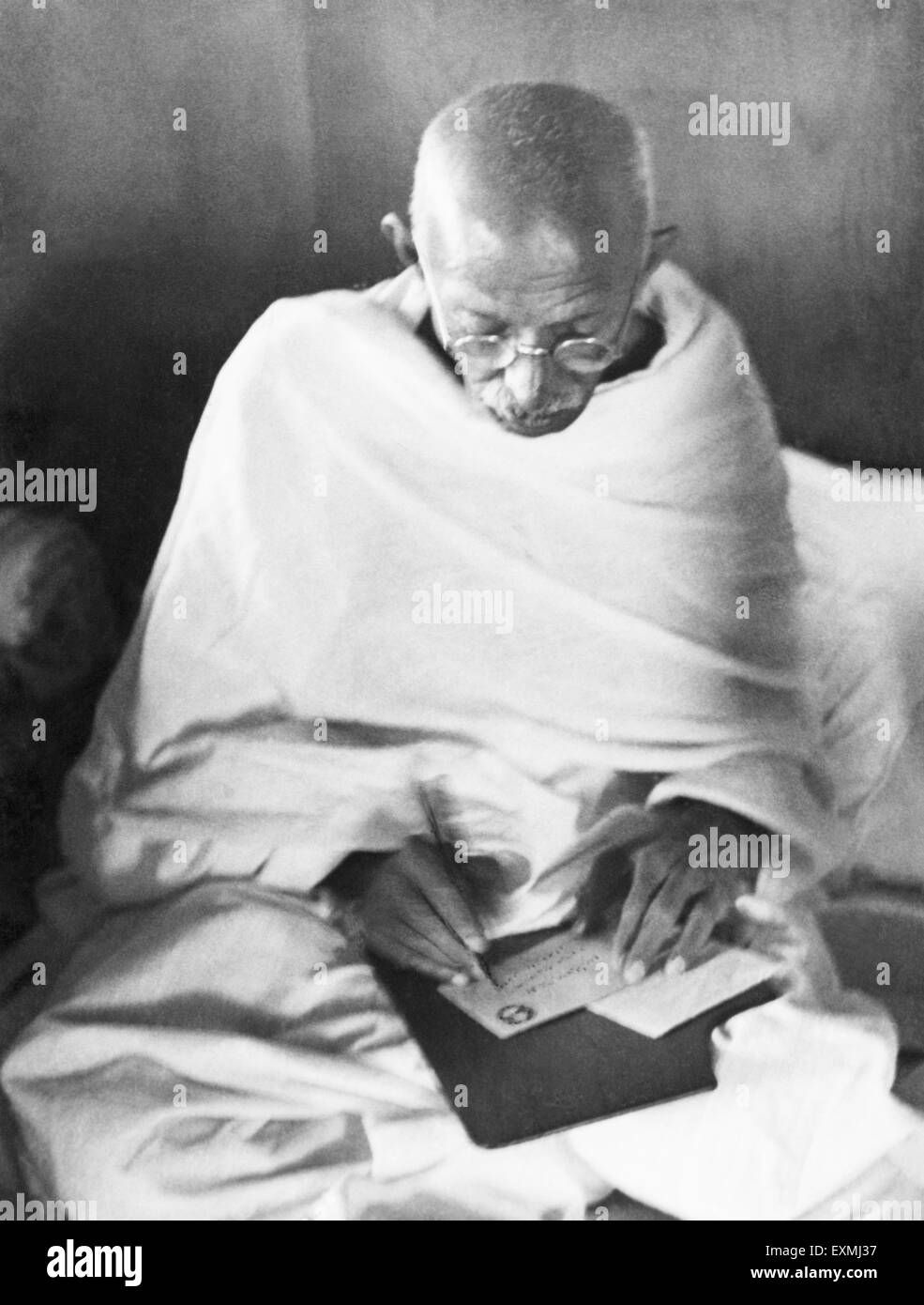 Mahatma Gandhi schreibt eine Adresse auf einem Umschlag in seiner Hütte in Sevagram Ashram Wardha Nagpur Indien 1944 altes Vintage 1900er Jahre Bild Stockfoto