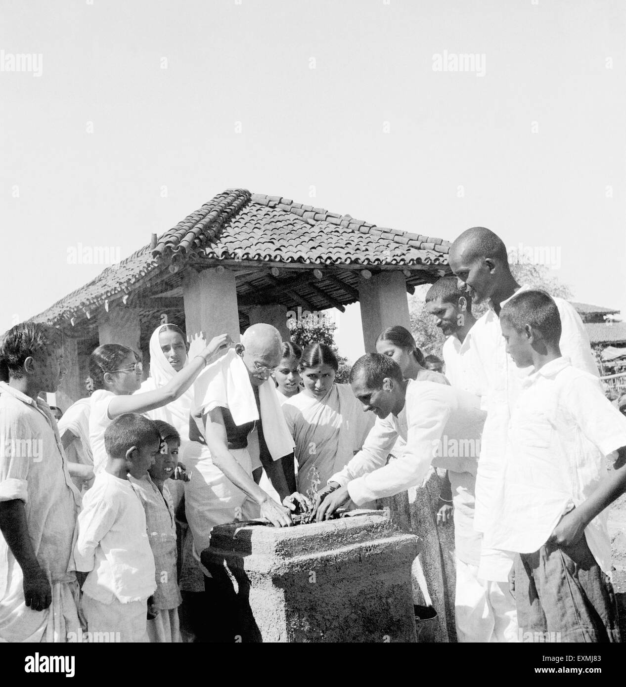 Mahatma Gandhi pflanzt einen Tulsi-Baum im Sevagram Ashram; 1946; C Durga Mehta; 2. l von Mahatma Gandhi Abha Gandhi keine Herr Stockfoto