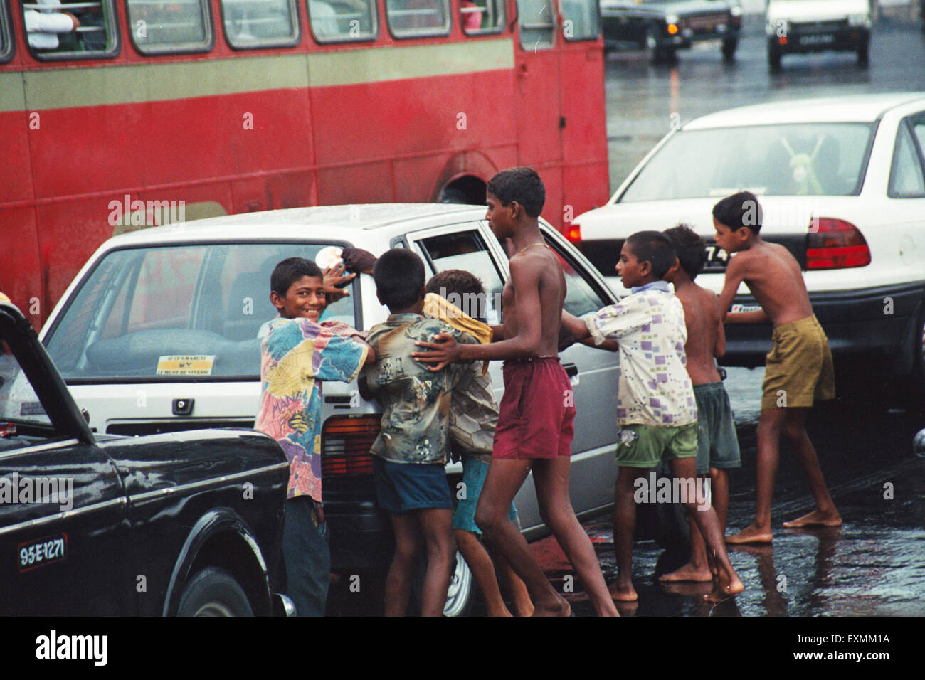 Straßenkinder Reinigung Auto Brille im Monsun-Regen und anspruchsvolle Geld Bombay Mumbai Maharashtra, Indien Stockfoto