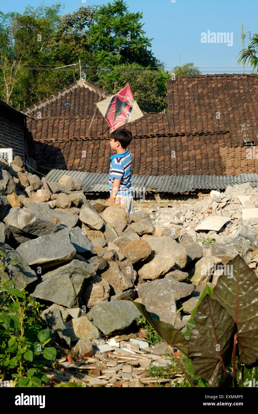 ein kleiner Junge spielt mit seinen hausgemachten Kite auf Brachland in einem kleinen Dorf in Java Indonesien allein Stockfoto