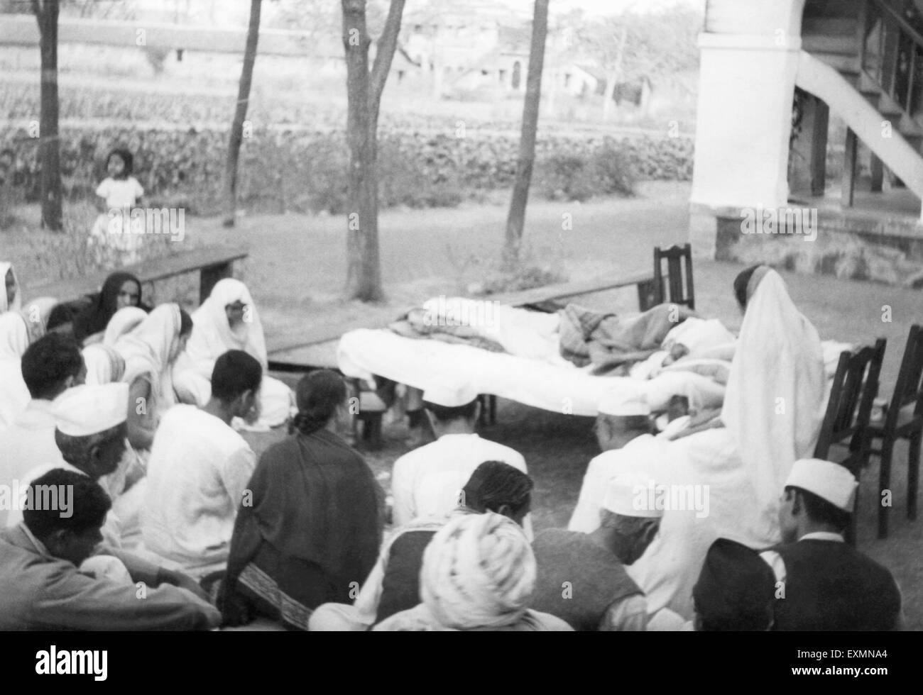 Mahatma Gandhi außerhalb ruhen; Menschen, die neben ihm auf dem Boden sitzend; 1944; Indien Stockfoto