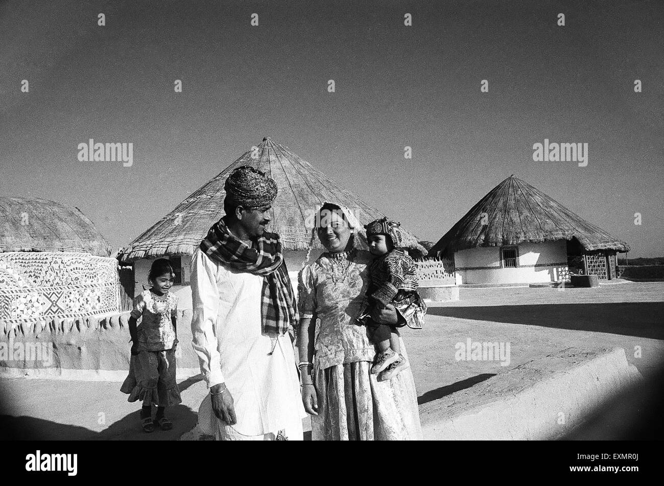 Dorfbewohner Familie und urige Hütten im Hintergrund Hudko Kutch Gujarat Indien Stockfoto