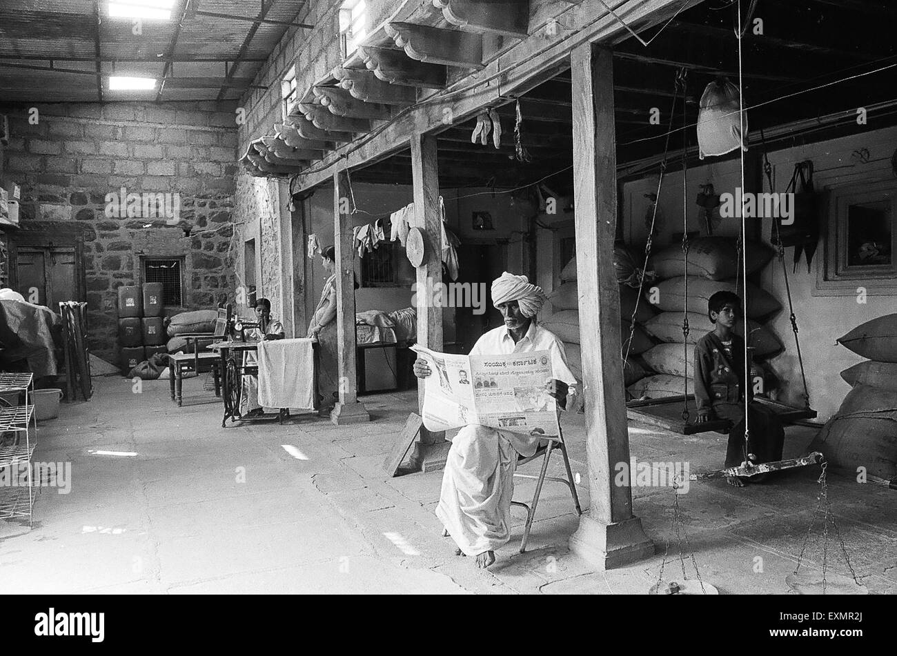 Interieur zeigt gespeicherte gestapelt Taschen einige Bewohner arbeiten oder entspannen Sie im Dorf Munagli in Bijapur Karnataka Indien Stockfoto