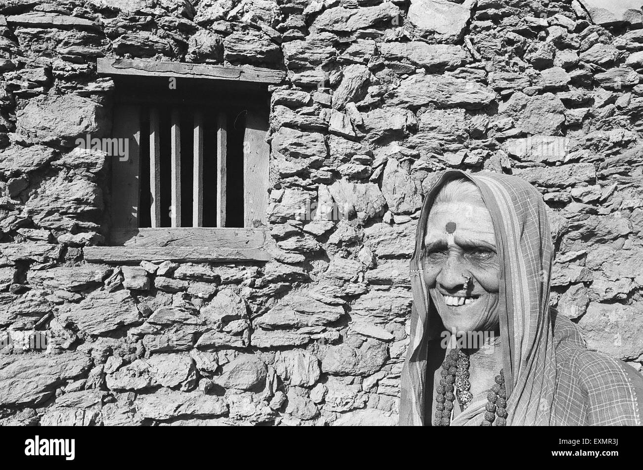 Ländliche Frau stand vor ihrem Haus Steinwand; Lokur Dorf; Dharwar Bezirk; Bijapur Bezirk; Karnataka; Indien Stockfoto