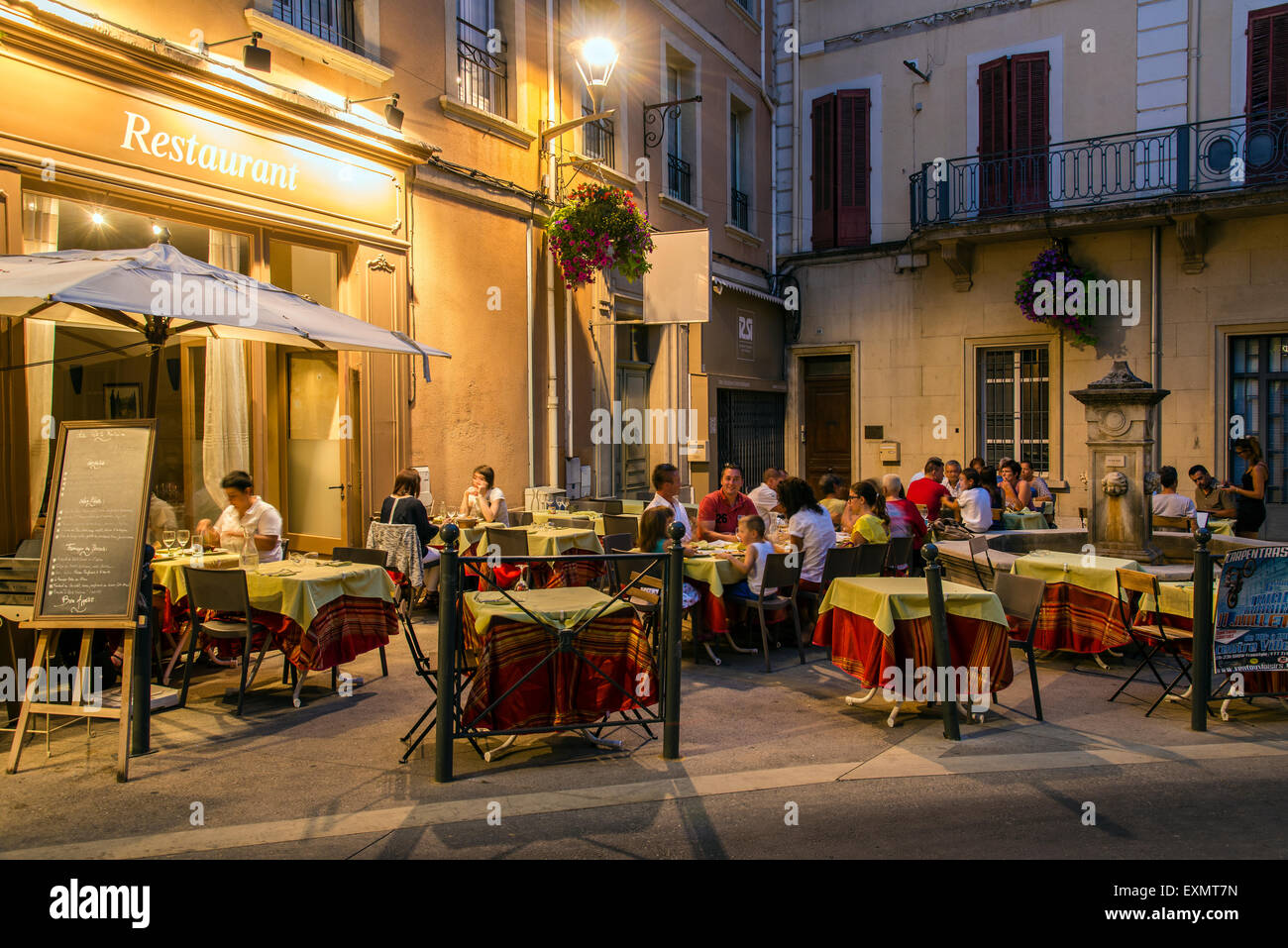 Nachtansicht der ein Restaurant mit Sitzplätze draußen an Tischen, Carpentras, Provence, Frankreich Stockfoto