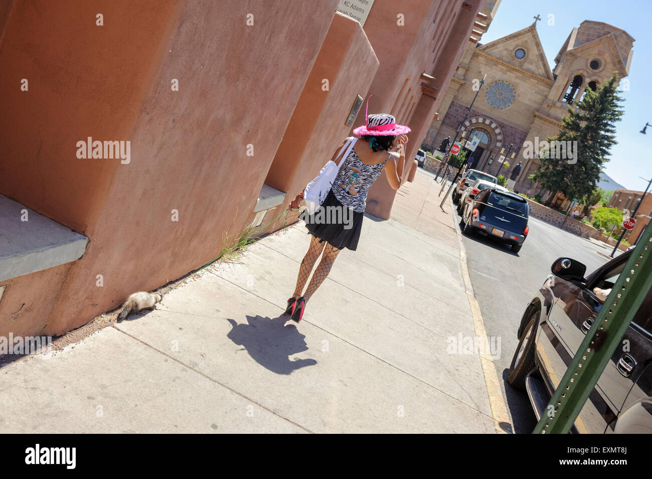 Eine junge Frau, ihr Haustier Frettchen von The St Francis Cathedral, Santa Fe, New Mexico, USA Stockfoto