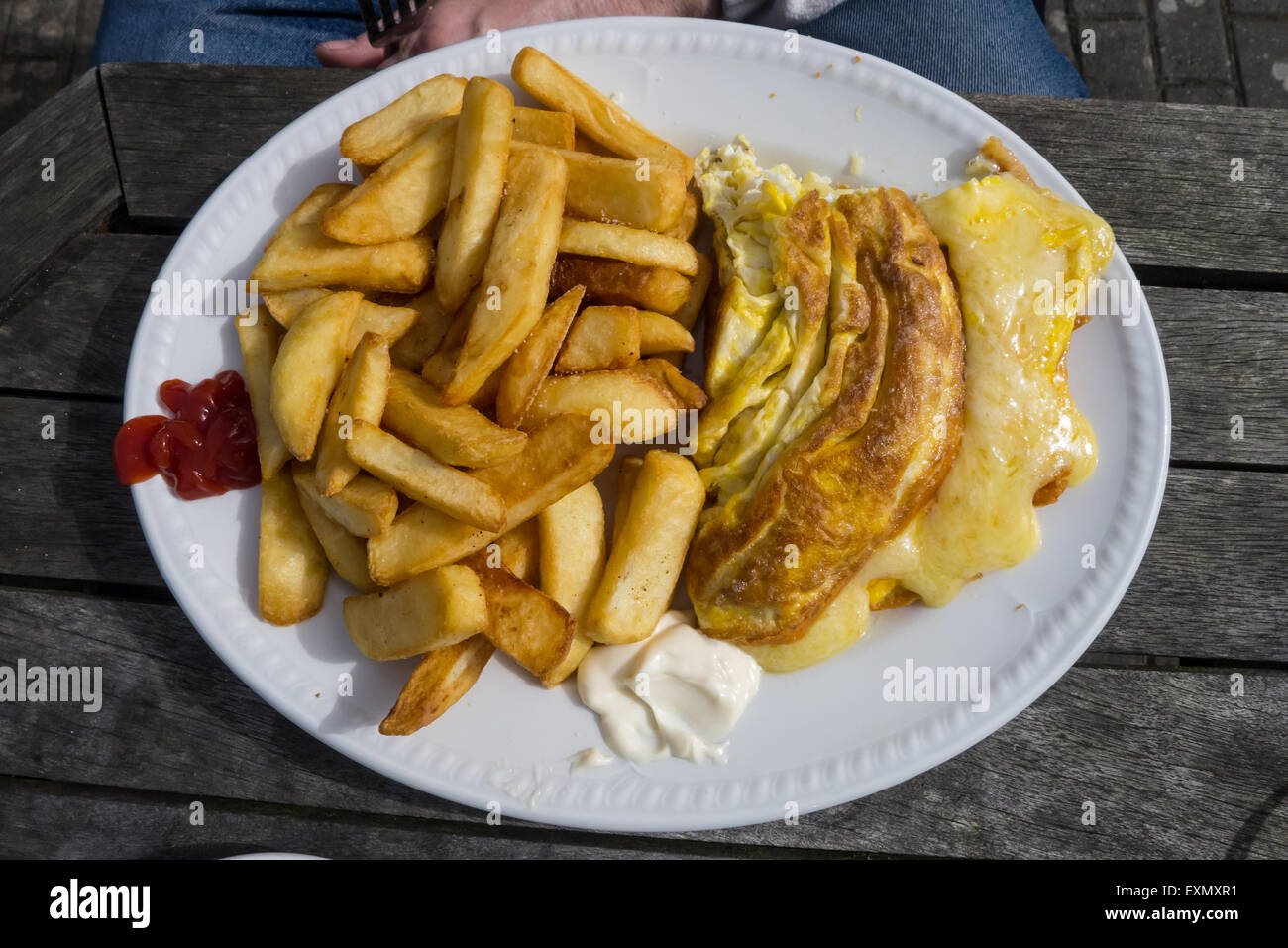Cornwall, England. Käse Omelette und Chips, Mayonaise und Ketchup. Stockfoto