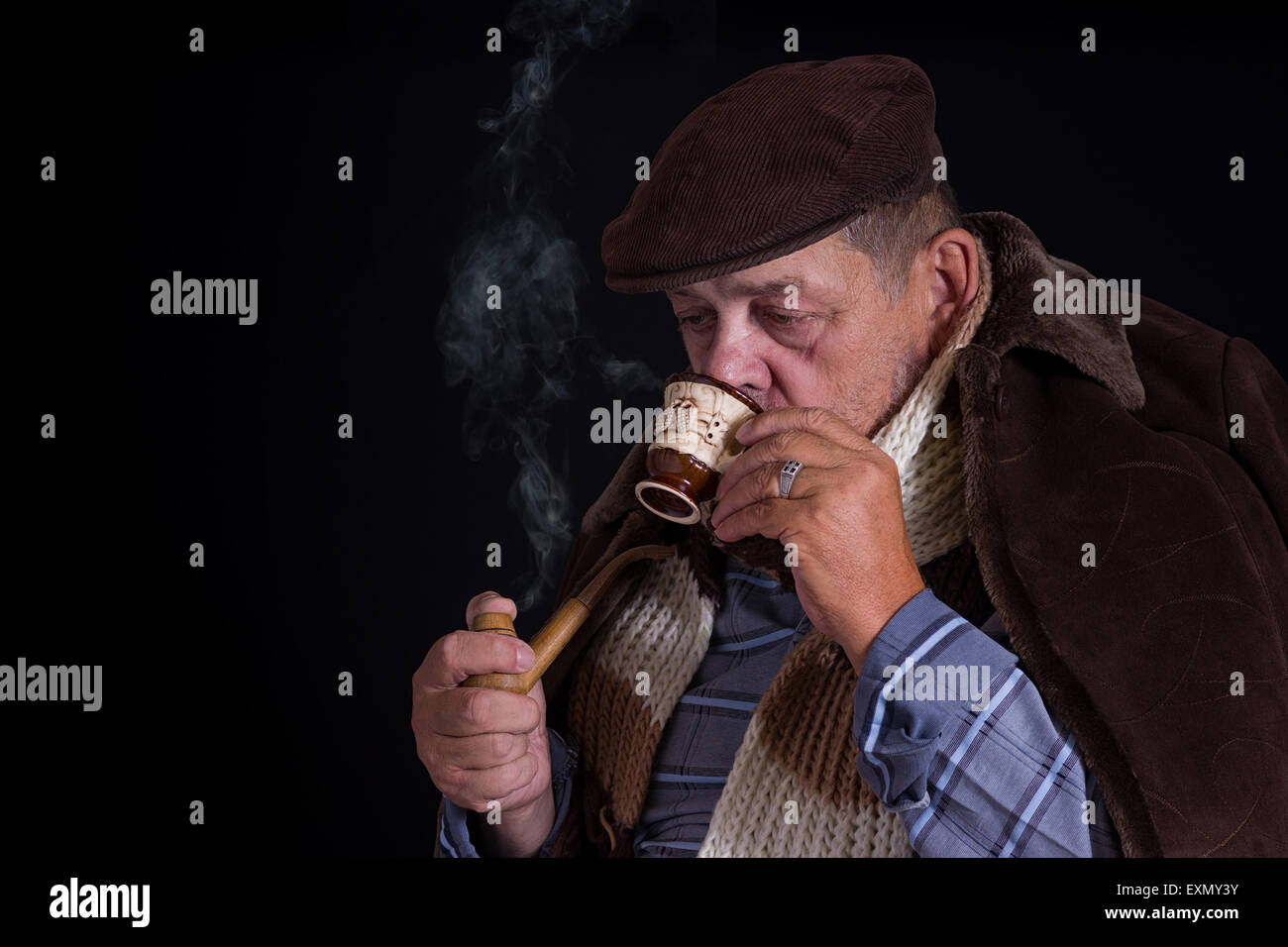 Senior woman wird gekühlt, bis auf die Knochen Kaffee trinkt und raucht Pfeife in der Dunkelheit Stockfoto