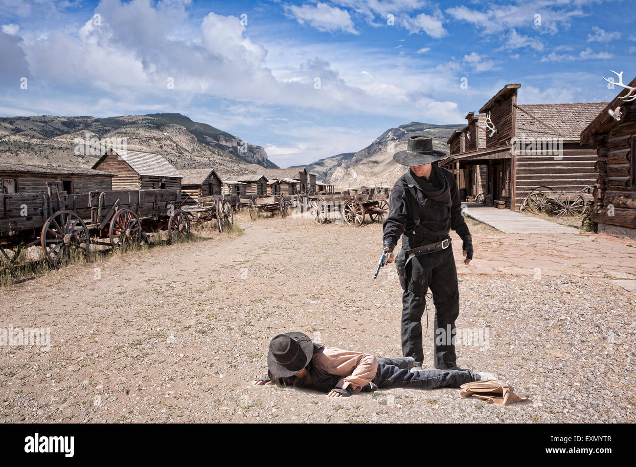 Zwei Cowboys in der Straße, auf dem Boden und das andere mit einer Pistole auf ihn, Old Trail Town, Cody, Wyoming, USA. Stockfoto