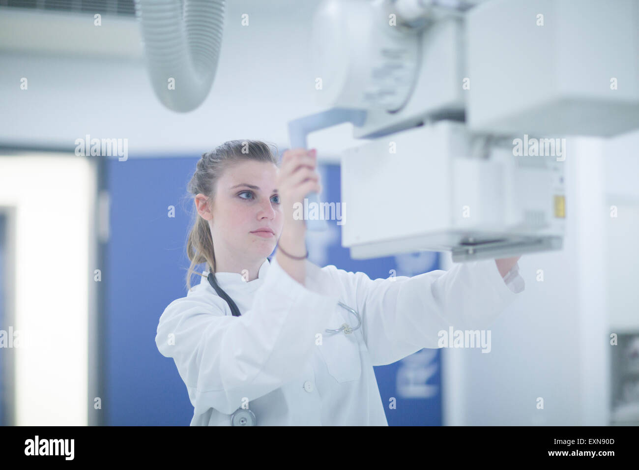 Junge Ärztin im Krankenhaus am Röntgengerät anpassen Stockfoto