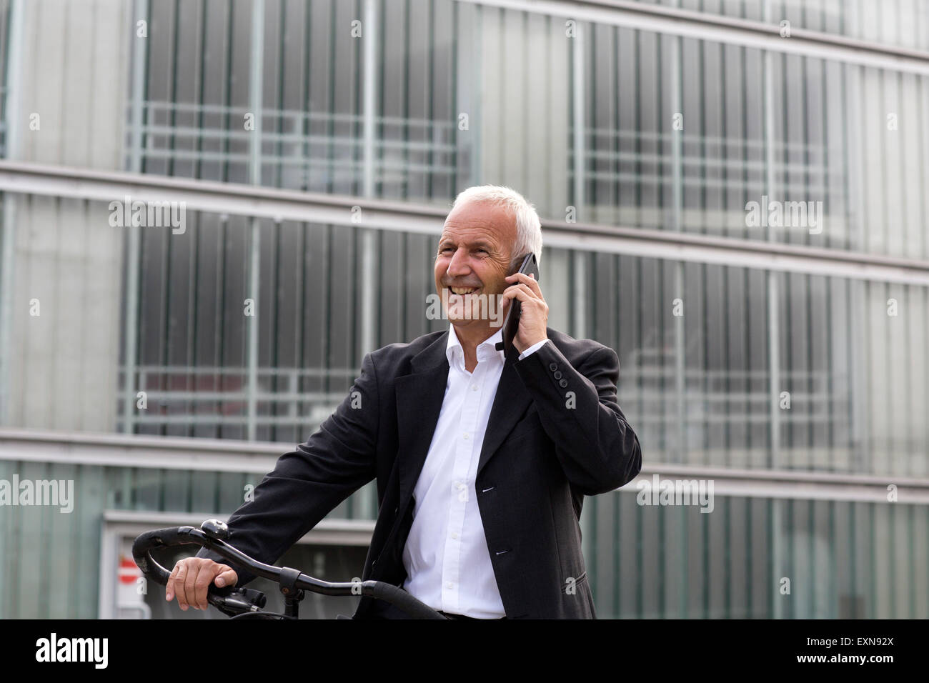 Geschäftsmann mit Fahrrad telefonieren mit smartphone Stockfoto