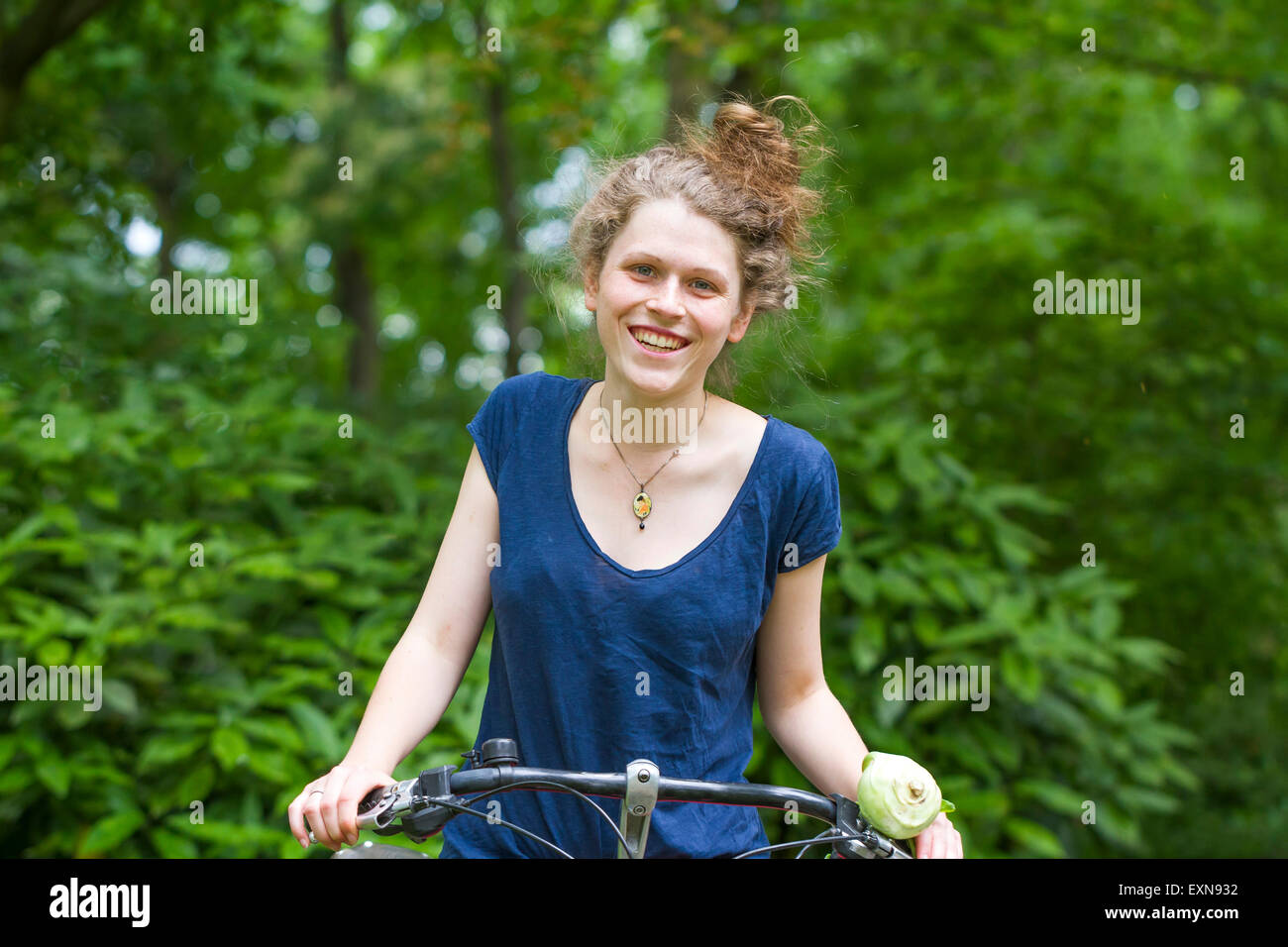 Porträt der lächelnde junge Frau Reiten Fahrrad Stockfoto