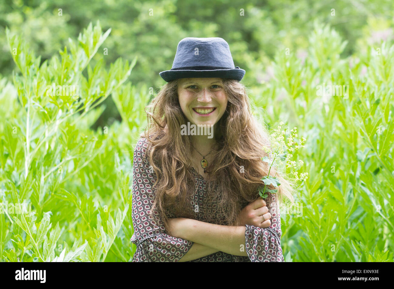 Porträt der lächelnde junge Frau mit Hut in der Natur Stockfoto