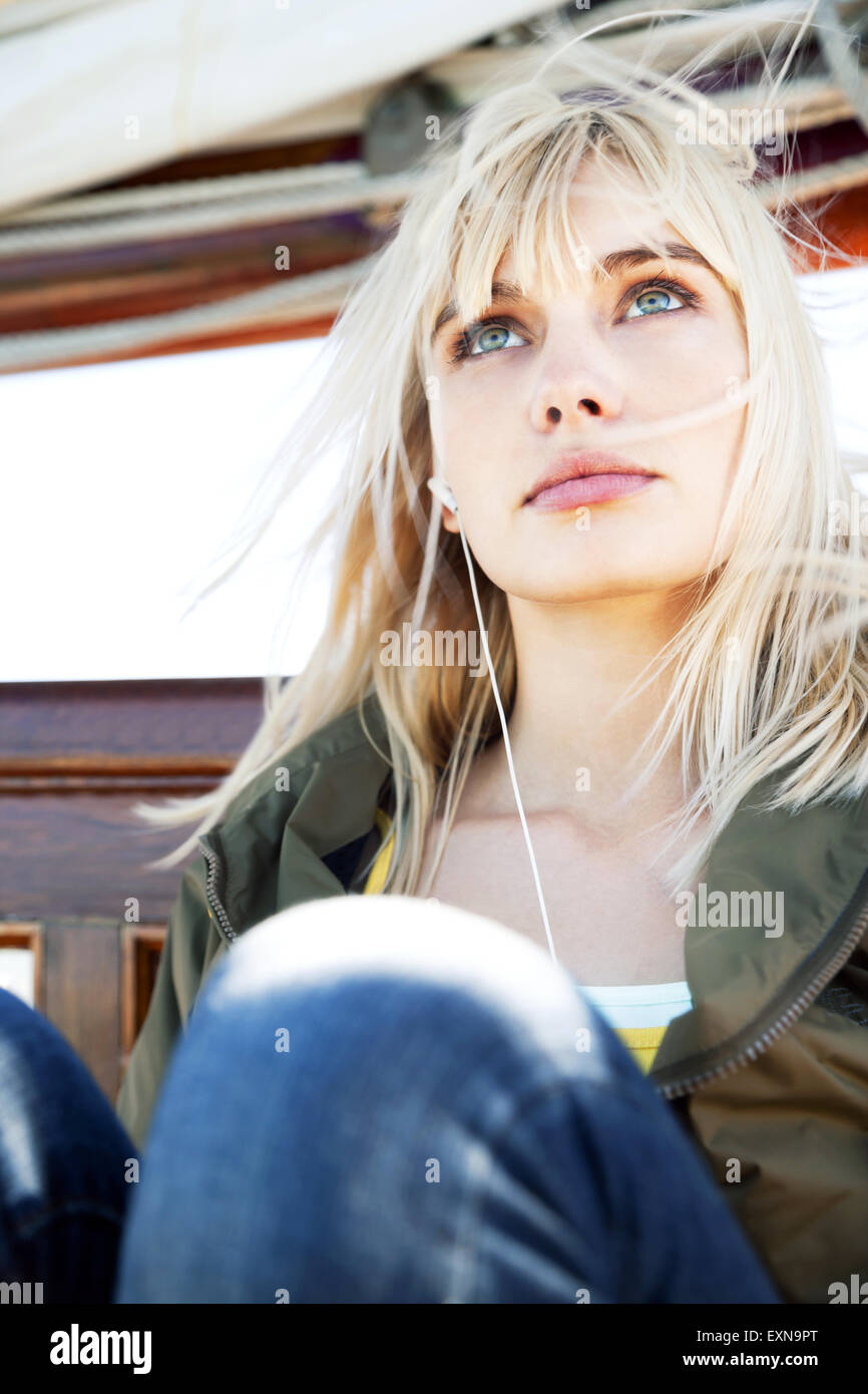 Junge Frau auf einem Segelschiff, das Anhören von Musik Stockfoto